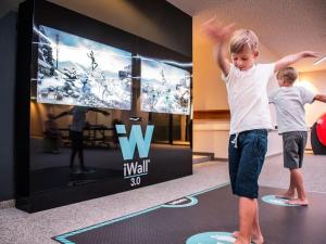 a young boy standing on a rug in front of a tv at Hotel Nummerhof in Erding