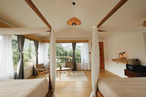 a bedroom with two beds and a desk and a table at Campgrounds at Mantalongon in Dalaguete +57 photos