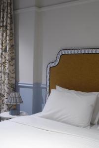 a bed with white sheets and a wooden headboard at No 9 Springfield in Sydney
