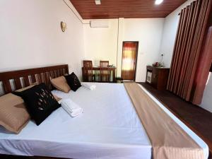 a bedroom with a large white bed with two pillows at Villa Mistica - Hiriketiya Dikwella in Dickwella