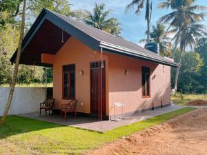 a small house with a porch and two chairs at Villa Mistica - Hiriketiya Dikwella in Dickwella +9 photos