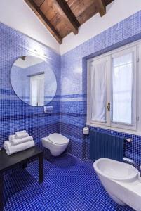 ミラノにあるAppartamento Cairoliの青いタイル張りのバスルーム(洗面台、トイレ付)