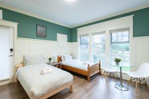 a bedroom with two beds and a table and chairs at 3Beds Ground-Level Private Suite in Burnaby in Burnaby