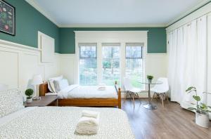 a bedroom with two beds and a table and chairs at 3Beds Ground-Level Private Suite in Burnaby in Burnaby +3 photos