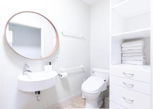 a white bathroom with a sink and a mirror at 3Beds Ground-Level Private Suite in Burnaby in Burnaby