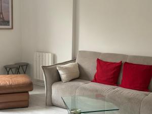 a living room with a couch with two red pillows at Disney 4 min, from 4 to 14 Guests, 4 bedrooms, free parkings, 100 m2 in Chessy