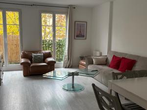 a living room with a couch and a glass table at Disney 4 min, from 4 to 14 Guests, 4 bedrooms, free parkings, 100 m2 in Chessy +39 photos
