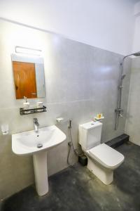 a bathroom with a sink and a toilet and a mirror at Negombo Lagoon Hideaway in Negombo +30 photos
