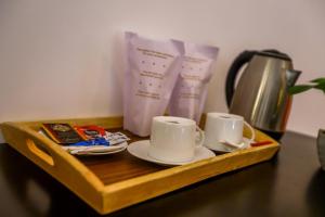 a tray with cups and saucers on a table at Negombo Lagoon Hideaway in Negombo