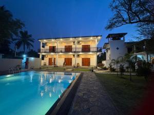 a large house with a swimming pool in front of it at Negombo Lagoon Hideaway in Negombo