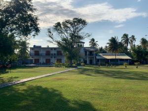 a large building with a large grassy field in front of it at Negombo Lagoon Hideaway in Negombo