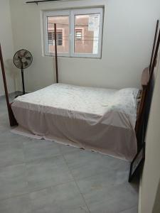 a small bed in a room with a window at Christal house in Abomey-Calavi