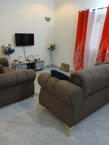 a living room with two couches and a tv at Christal house in Abomey-Calavi