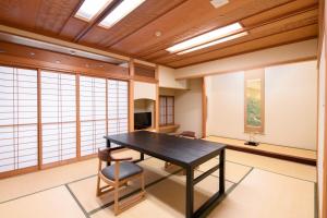 a dining room with a table and chairs in a room at Furuya Ryokan in Atami