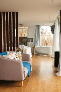 a living room with a couch and a bath tub at Cabana Greece house blue in Paty do Alferes