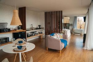 a living room with a couch and a table at Cabana Greece house blue in Paty do Alferes
