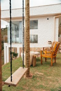 a swing in the yard of a house at Cabana Greece house blue in Paty do Alferes