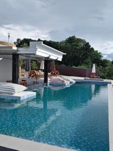 a swimming pool with chairs and umbrellas and a swimming pool at Viera Resort in Ngurblut