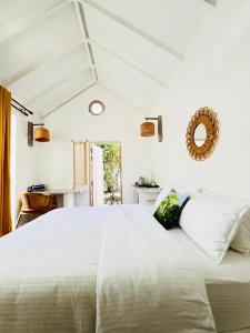 a bedroom with a large white bed with a mirror at 101 Sosi in Kudafari