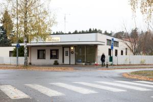 a woman walking her dog in front of a building at Gasthaus Mikkeli in Mikkeli