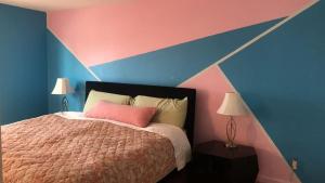 a bedroom with a bed with a pink and blue wall at 4 Bedroom Vacation House With Pikes Peak view Pet-friendly in Aurora +22 photos