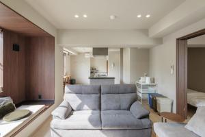 a living room with a couch and a kitchen at A&m花畑401 in Kumamoto