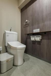 a bathroom with a white toilet and a wooden wall at A&m花畑401 in Kumamoto