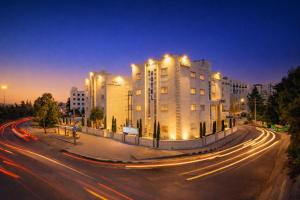 a city street with a large building with lights at Al Basem Hotel in Amman