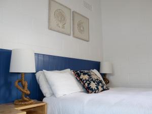 a bedroom with a bed with a blue headboard at Modra's Apartments in Tumby Bay