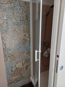 a bathroom with a shower with a stone wall at Hôtel de la Mer in Valras-Plage +72 photos