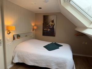 a bedroom with a bed and a painting on the wall at 't Zeeuwse licht in Middelburg