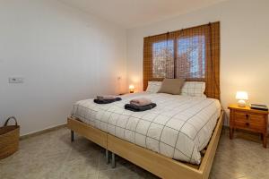 a bedroom with a bed and a window and two lamps at El Nido Apartment in Acantilado de los Gigantes
