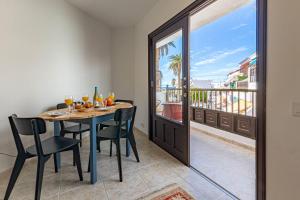 a dining room with a table and chairs and a balcony at El Nido Apartment in Acantilado de los Gigantes