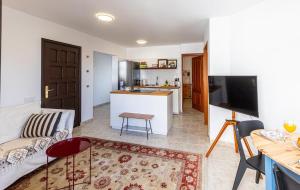 a living room with a couch and a kitchen at El Nido Apartment in Acantilado de los Gigantes