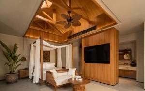 a bedroom with a bed and a ceiling fan and a television at CongLinLi Wooded Homestay in Conghua