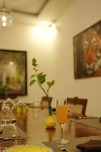 a glass of wine sitting on a wooden table at Ranthambhore Aangan in Khilchipur