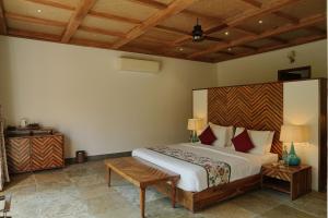 a bedroom with a large bed with a wooden headboard at Ranthambhore Aangan in Khilchipur +65 photos