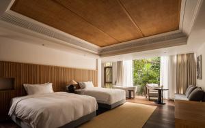 a bedroom with two beds and a table and a chair at CongLinLi Wooded Homestay in Conghua +112 photos