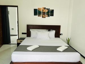 a bedroom with a large bed with two white towels at Dasis villa in Hiriketiya
