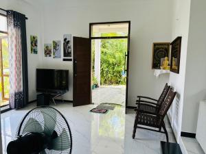 a living room with a door and a chair and a fan at Dasis villa in Hiriketiya