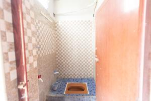 a small bathroom with a toilet in a stall at MAS Residency Home in Pudukkottai
