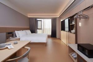 a large hotel room with a bed and a kitchen at JI Hotel Vientiane Mekong Riverside in Vientiane