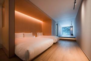 a bedroom with a large white bed and a window at 롯지호텔 디여라 in Andong