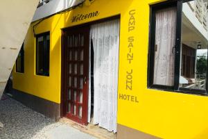 a yellow building with a red door and windows at Camp Saint John Hotel La Union in San Juan