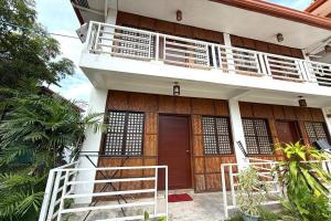 a house with a staircase leading up to the front door at Camp Saint John Hotel La Union in San Juan