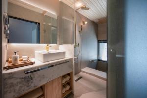 a bathroom with a sink and a mirror at 롯지호텔 디여라 in Andong