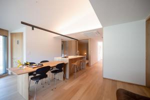 a kitchen and dining room with a wooden table and chairs at 롯지호텔 디여라 in Andong