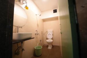 a bathroom with a sink and a toilet and a mirror at Zen Colive in Pune +66 photos