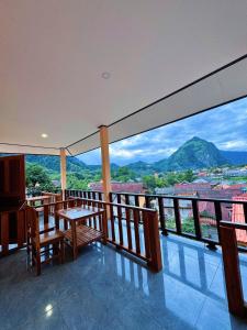 a balcony with a table and chairs and a view at phoulisack2 guesthouse in Nongkhiaw