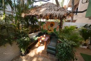 an outdoor patio with a table and a straw umbrella at Zen Colive in Pune